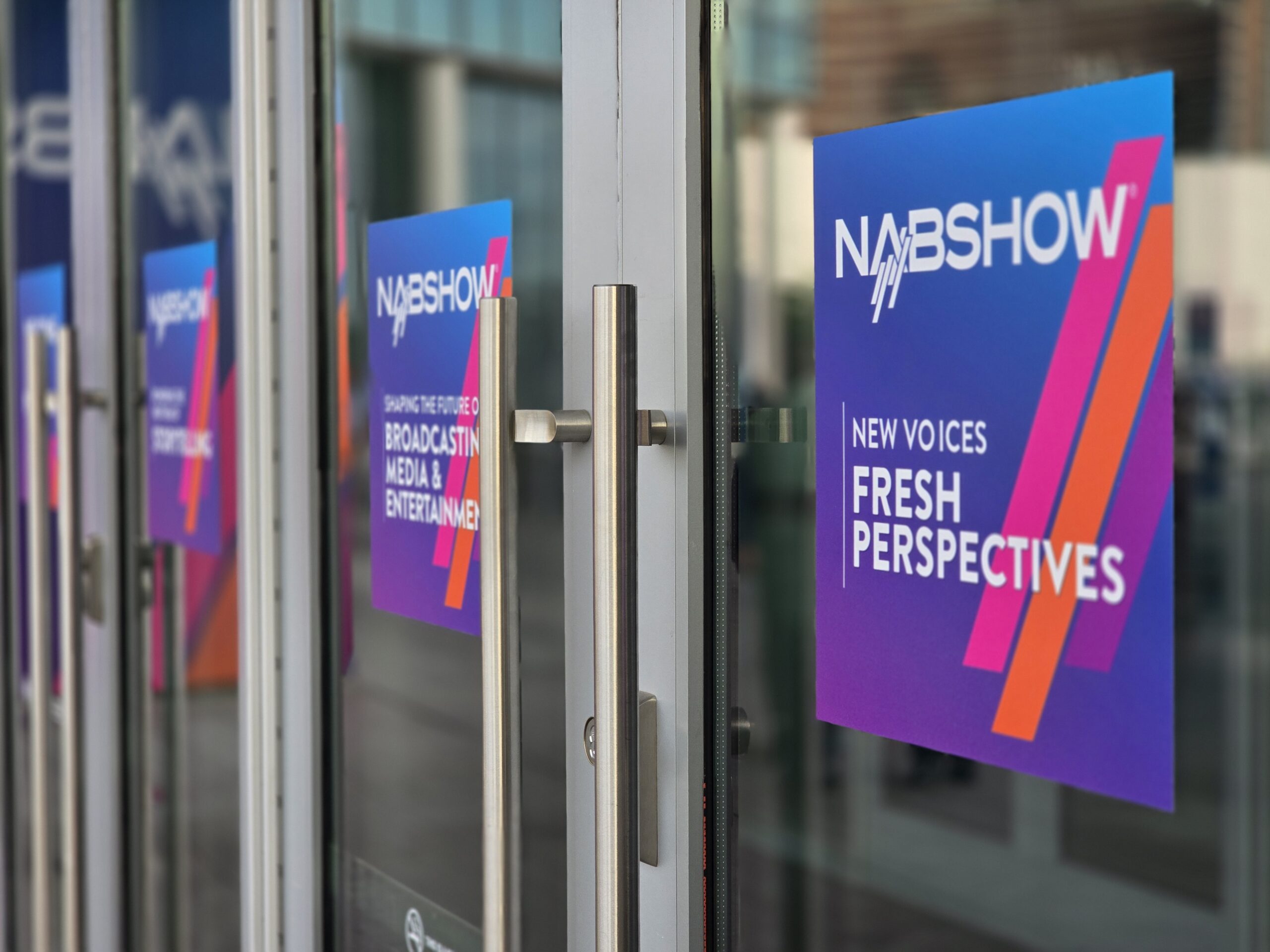 NAB 2025 entrance with NAB logo and the tagline "new voices, fresh perspectives" poster on the entrance door